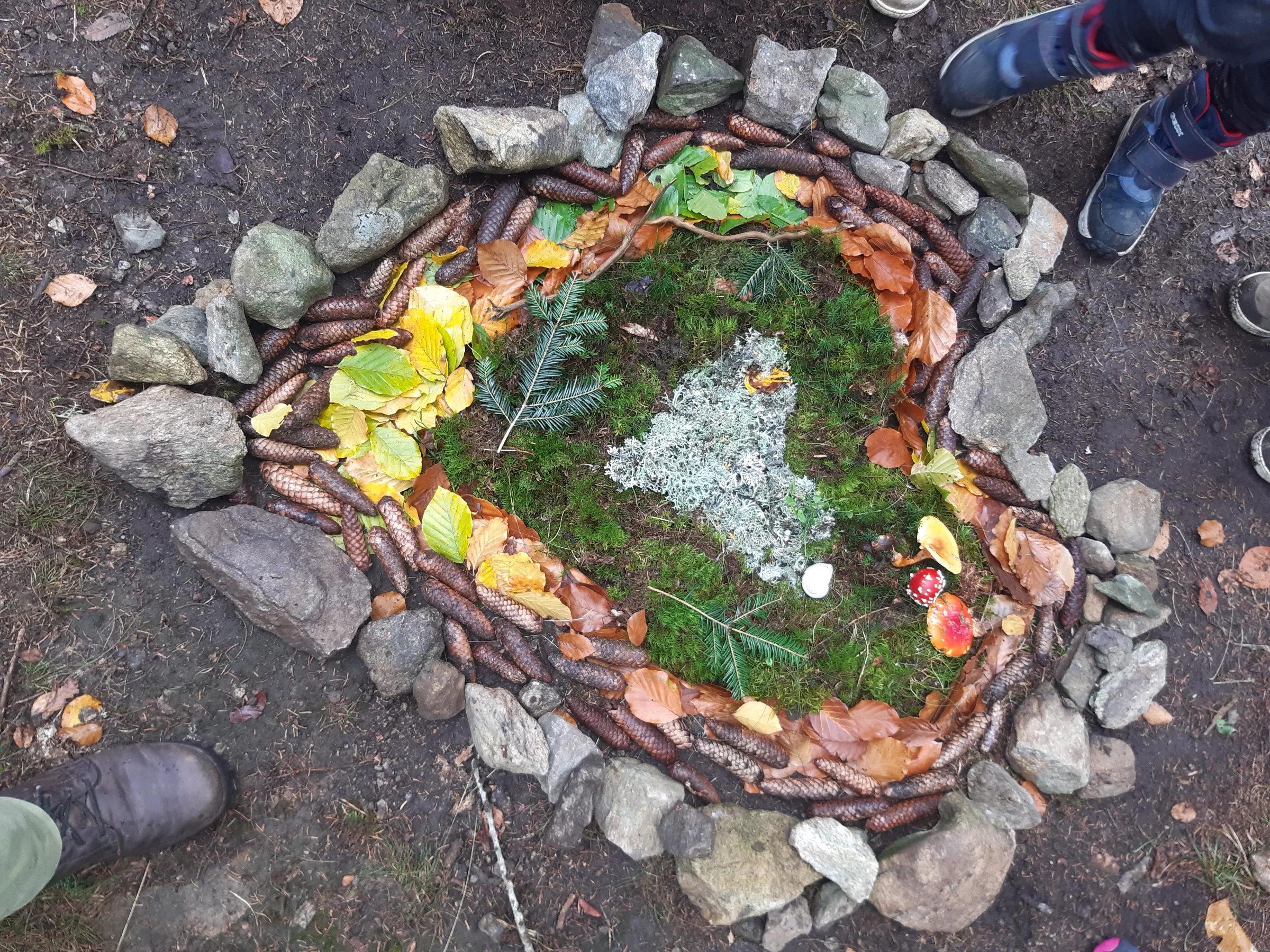 Ein Waldmandala aus Steinen, Blättern und Moos