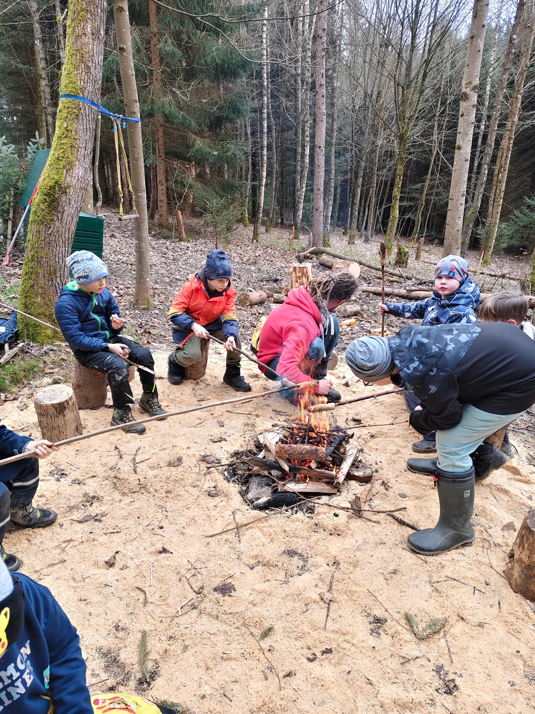 Kinder braten Stockbrot am Lagerfeuer