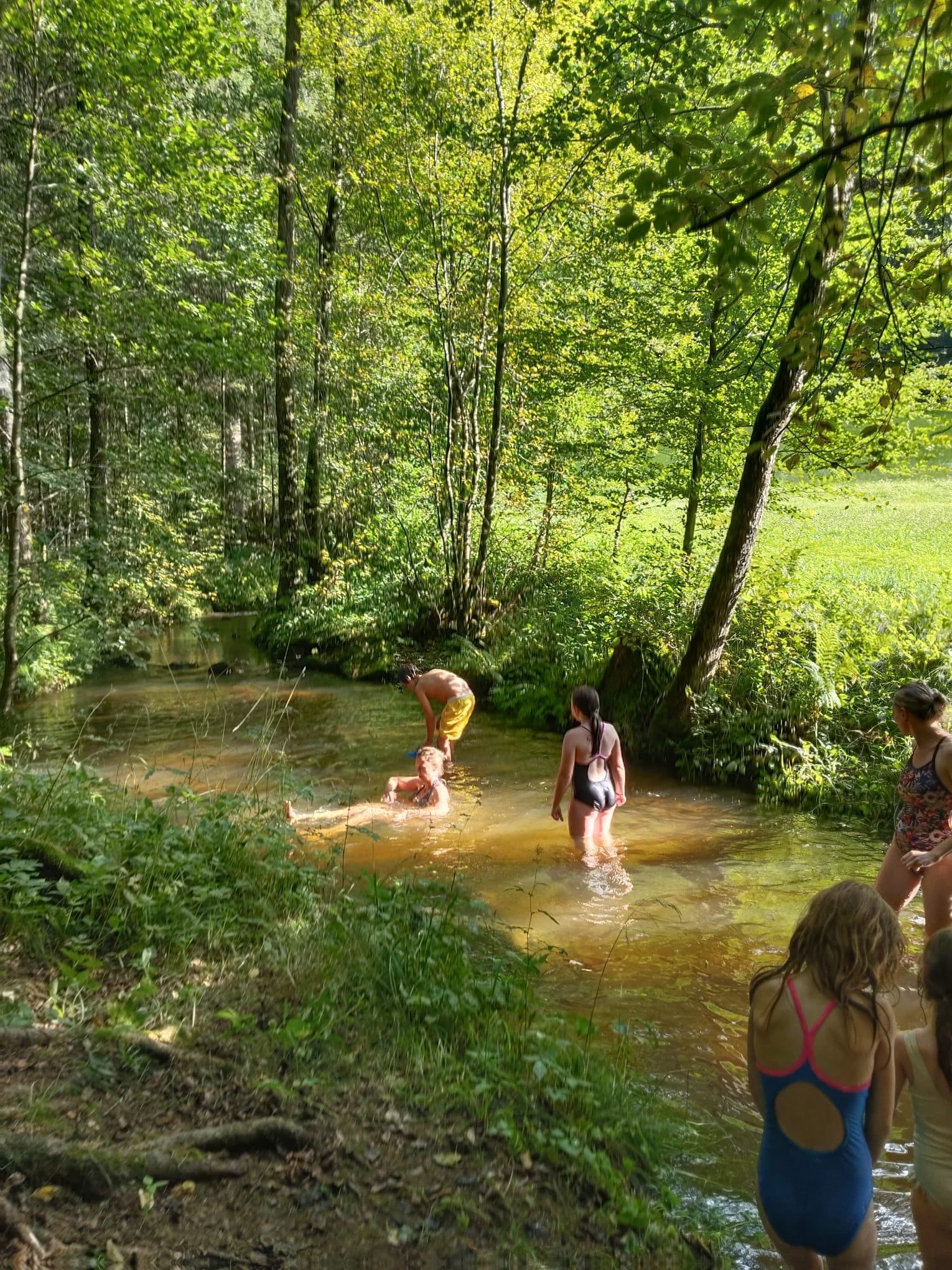 Kinder kühlen sich an einem heißen Sommertag im Bach ab