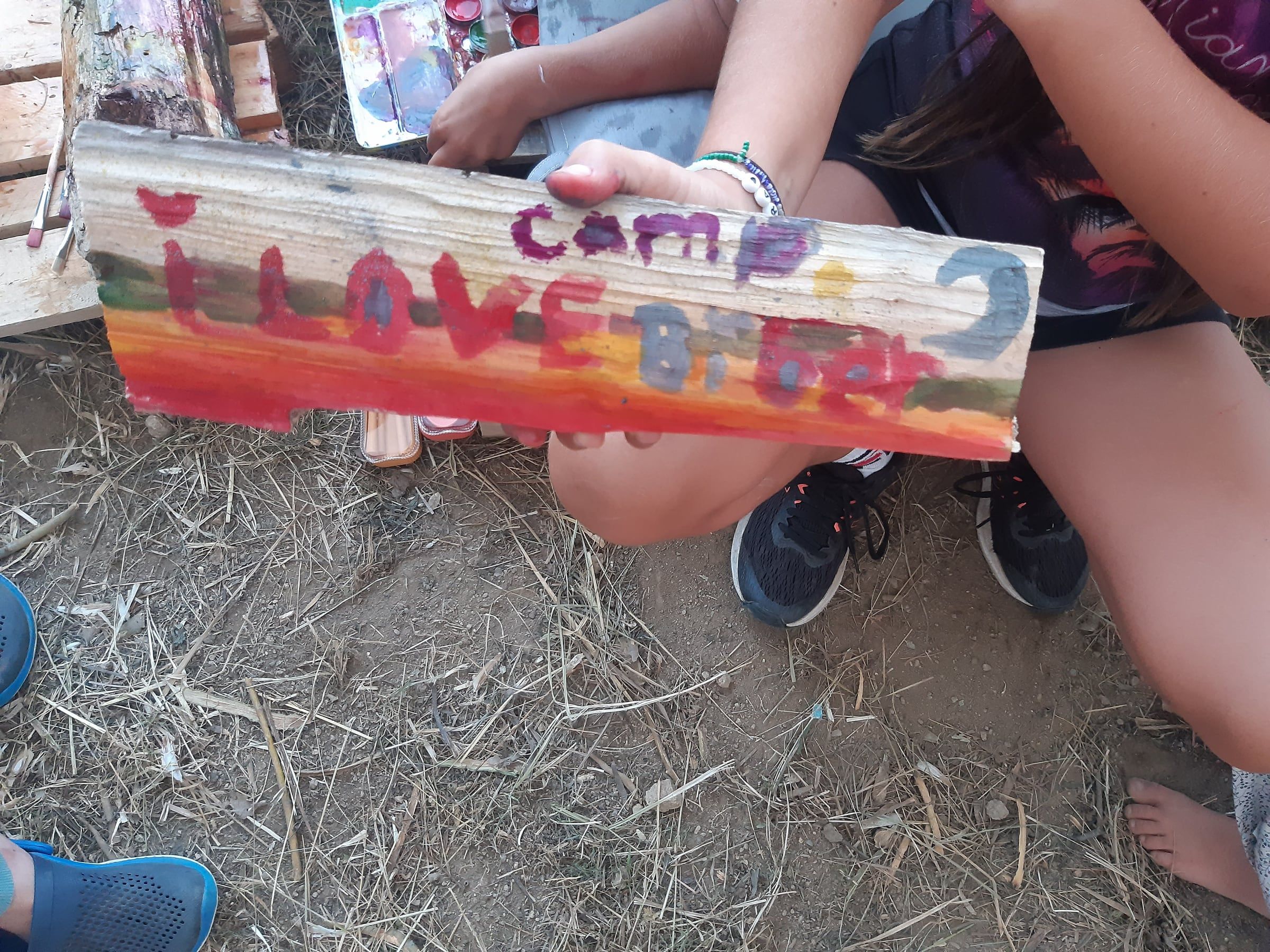 Ein selbst bemaltes Holzschild vom Camp
