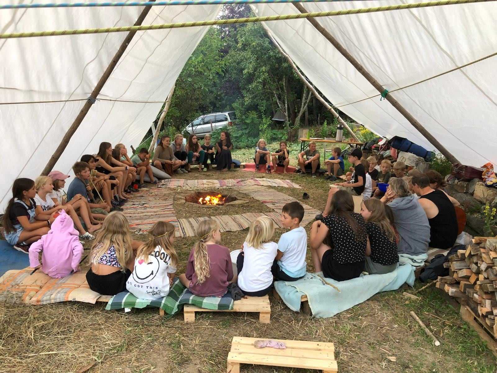 Morgenkreis um die Feuerstelle unter dem großen Tarp