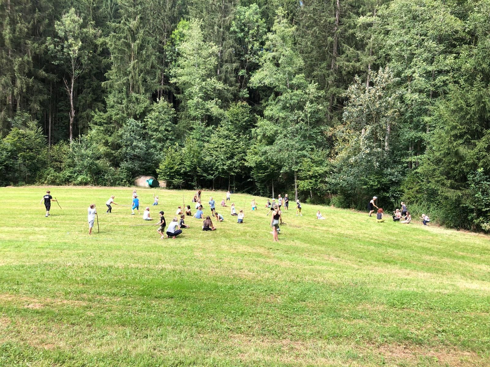 Gemeinsames Spiel auf der großen Wiese vor dem Wald